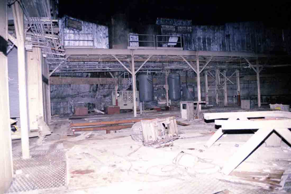 Abandoned industrial interior with debris and old machinery.