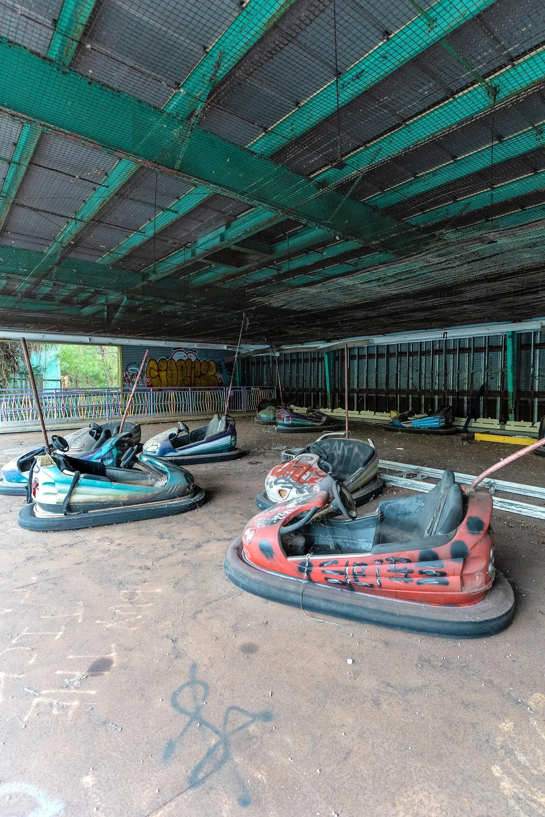 Abandoned bumper cars inside a decaying amusement structure